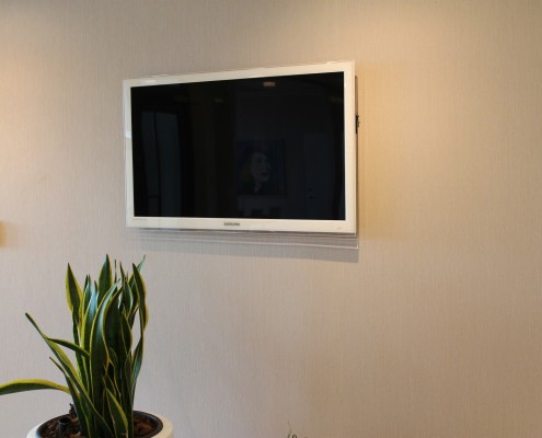 Vit entre-tv monterad på vägg